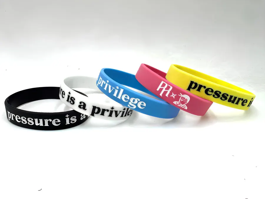 Pulseiras de silicone personalizadas em cinco cores, com textos e um logotipo aplicados.